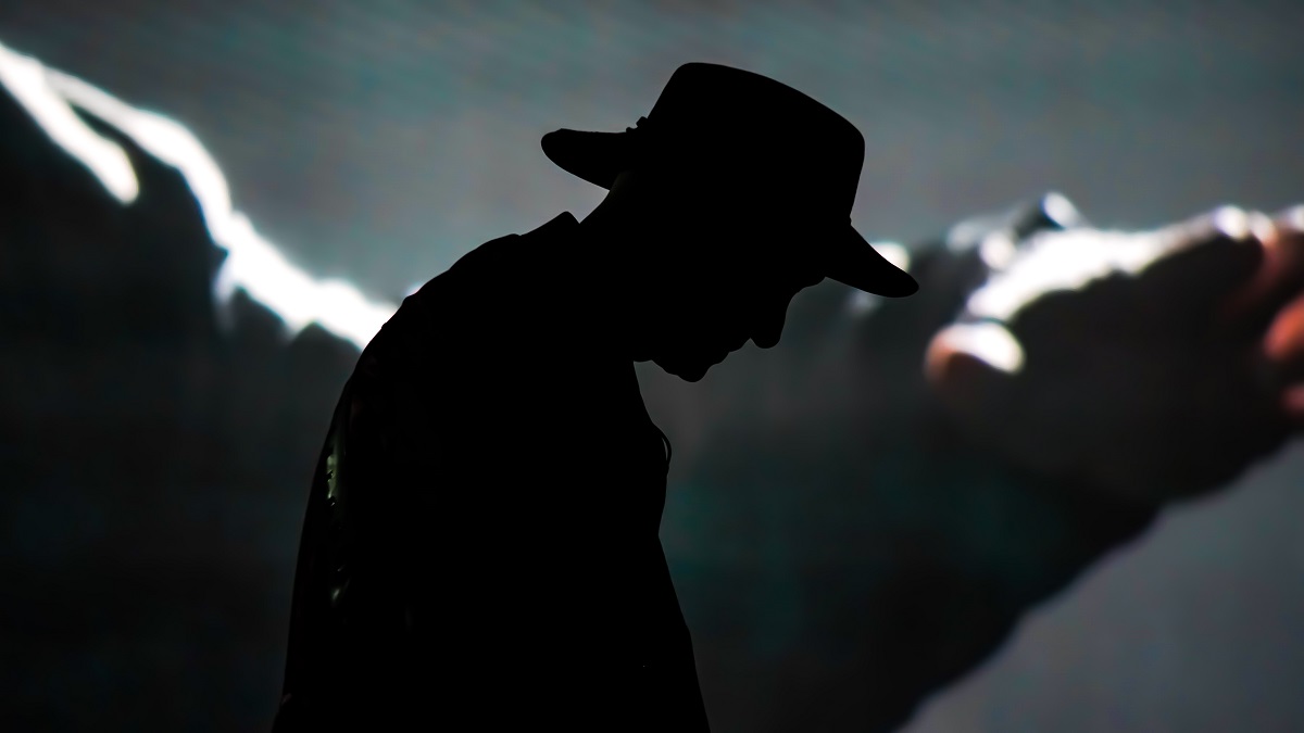 shadowy figure in black hat